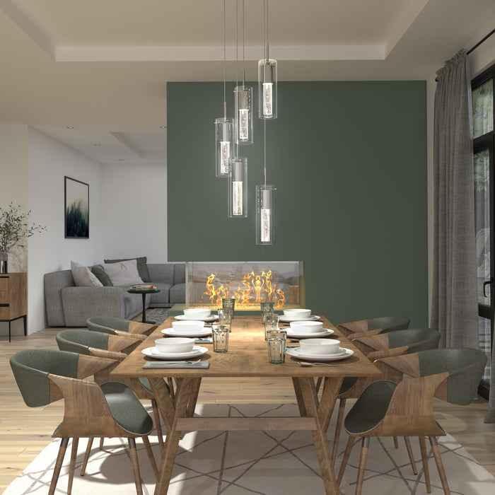 Modern dining room with wooden table set for eight, green accent wall, unique fireplace, and pendant lighting