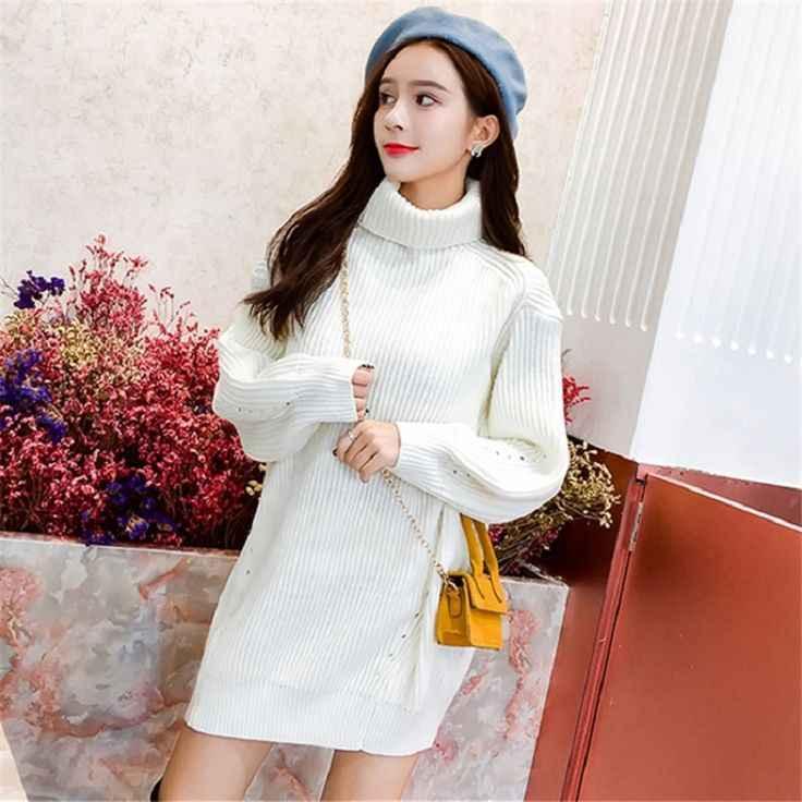 Young woman wearing white turtleneck knitted sweater dress and blue beret with yellow shoulder bag indoors