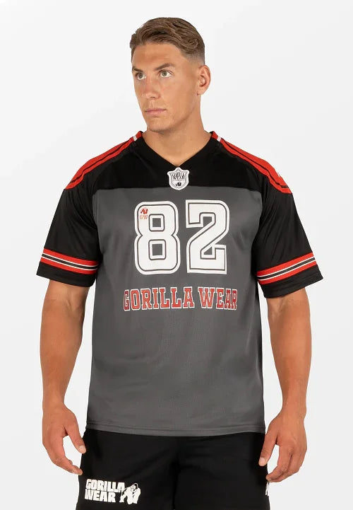 Athletic man wearing Gorilla Wear black and gray sports jersey with number 82 and red stripes