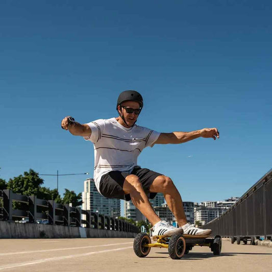 Man in helmet and sunglasses riding electric off-road skateboard on urban road with clear blue sky