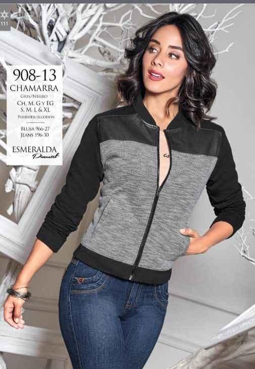 Woman wearing a black and gray zip-up chamara jacket and blue jeans posing indoors