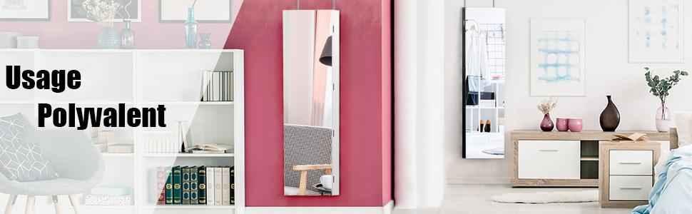 Modern living room with white bookshelf, pink accent wall, slim mirror, wooden sideboard, and cozy chair