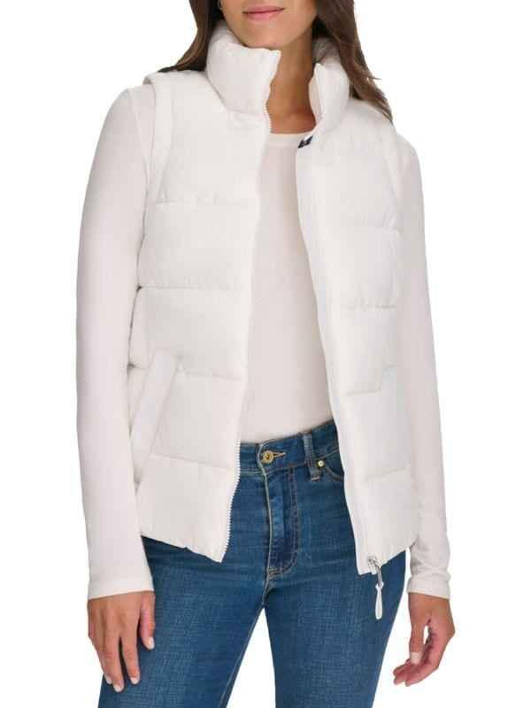 Woman wearing white quilted puffer vest over long sleeve white top and blue jeans
