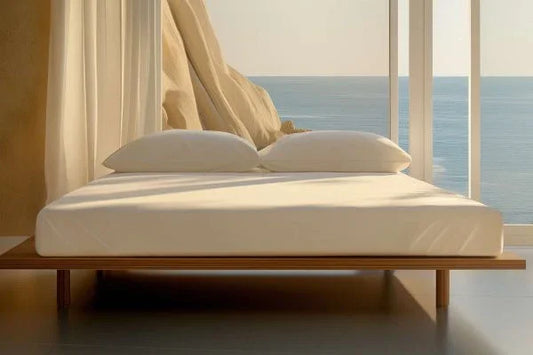 Minimalist bedroom with organic cotton sateen fitted sheet and pillows on wooden bed frame by ocean view